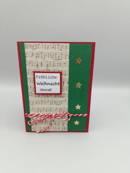 Handgemachte Weihnachtskarte mit Notenstreifen und Sternen – „Fröhliche Weihnacht überall“